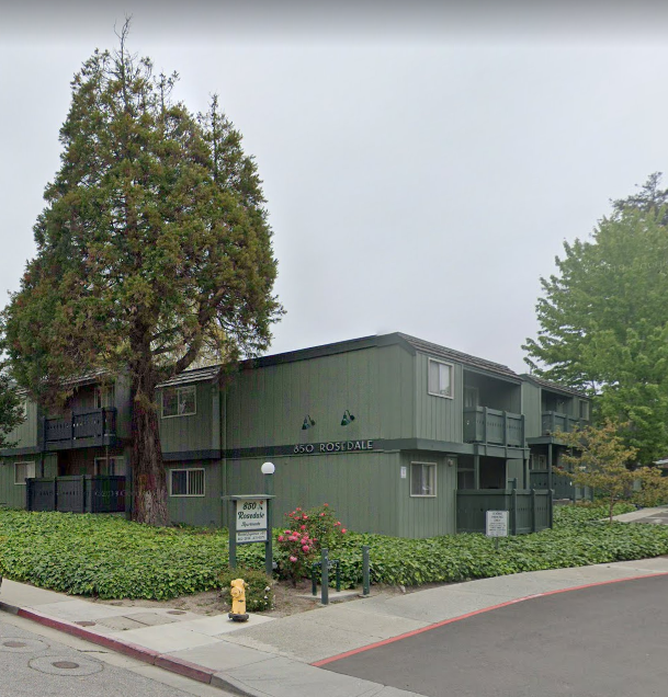 a green building with a tree in front of it